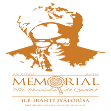 Memorial Mãe Menininha do Gantois cuja logomarca tem a foto da personalidade em cor dourada, escrita com letras garrafais e símbolo de um abebé (espelho), e traduzida para a língua iorubá.