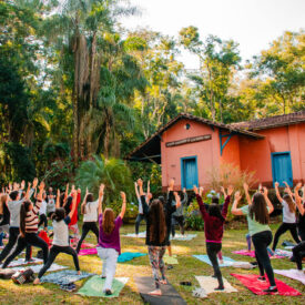 Na imagem visualizamos jovens praticando yoga diante da Estação Nova Baden, sede do Museu Comunitário de Lambari/MG.