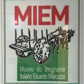 A logomarca do MIEM, foi criada por Douglas Menezes da Agência Estúdio Gare de Santa Maria e concebida em conjunto com a comissão de organização do Museu, criada para preservar, valorizar e divulgar a cultura e a memória da comunidade italiana de Vale Vêneto. A marca traz nas suas cores referência ao país de origem, as cores da bandeira italiana e referência ao local onde se instalaram, Vale Vêneto. A carroça puxada pelos bois, meio de transporte da época, simboliza a caminhada terrestre com a qual era possível desbravar montanhosas, terrenos acidentados como é a geografia do local.