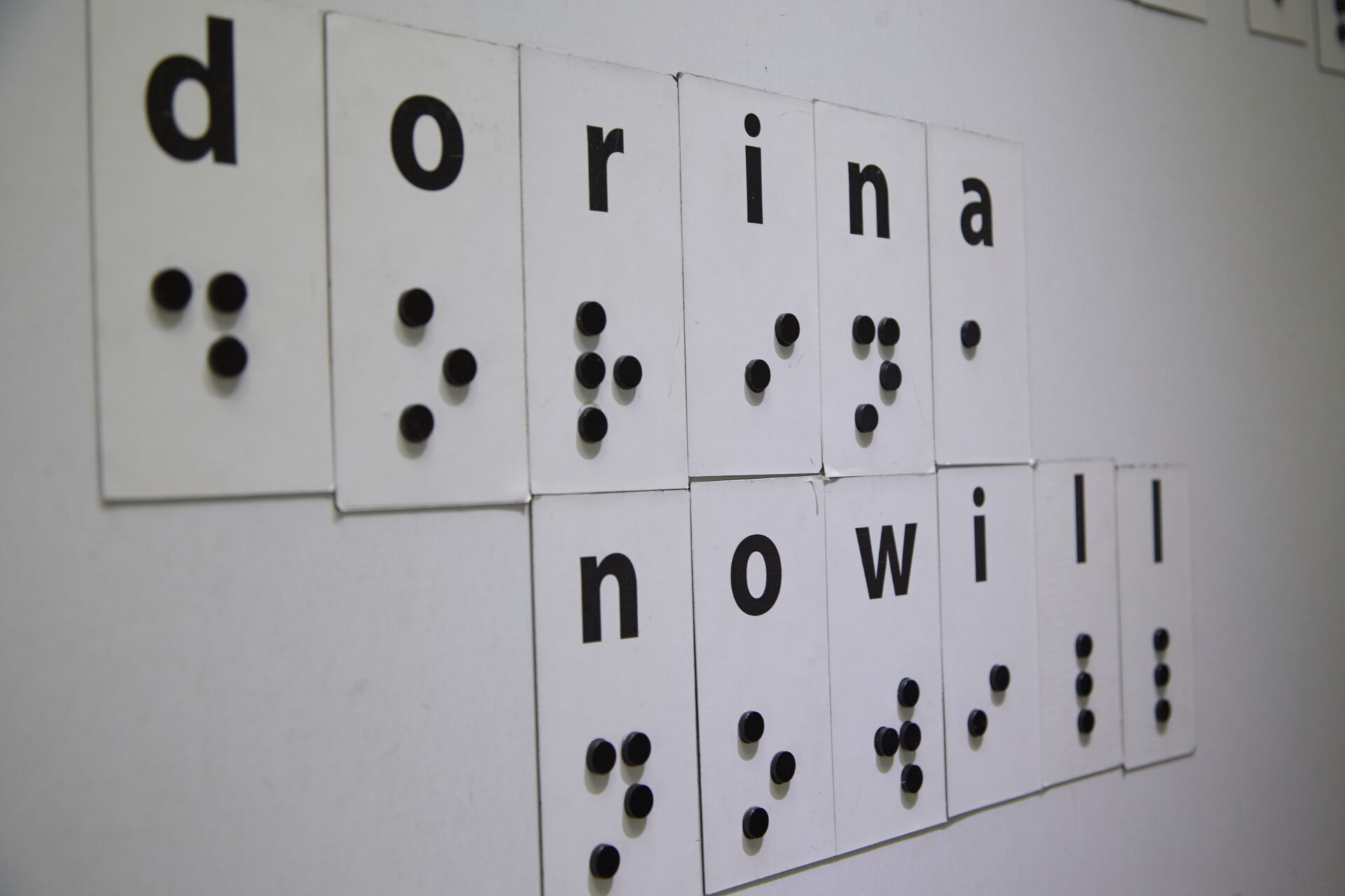Imagem de uma lousa branca com letras em Braille formando a palavra Dorina Nowill