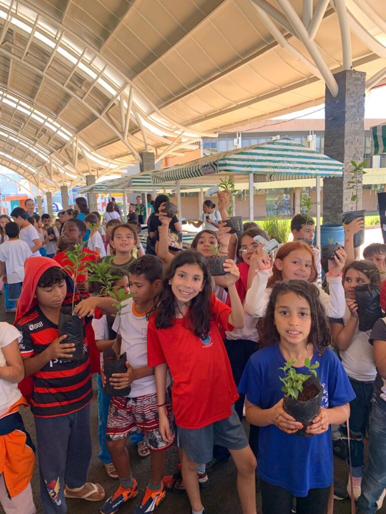 ALUNOS DAS ESCOLAS MUNICIPAIS APÓS GANHAREM MUDAS DE ÁRVORES DA OFICINA DO MEIO AMBIENTE.