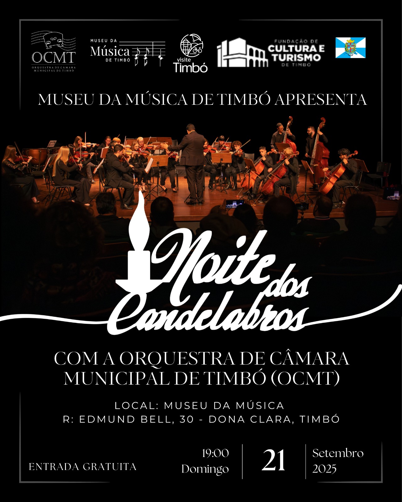 Cartaz do evento musical “Noite dos Candelabros”, promovido pelo Museu da Música de Timbó. A imagem de fundo mostra uma orquestra de câmara se apresentando no palco, com um maestro ao centro. O evento acontecerá no dia 21 de setembro de 2025, domingo, às 19h, no Museu da Música, localizado na Rua Edmund Bell, 30, bairro Dona Clara, Timbó. A entrada é gratuita. A apresentação será feita pela Orquestra de Câmara Municipal de Timbó (OCMT). O cartaz inclui os logotipos do Museu da Música de Timbó, da Fundação de Cultura e Turismo de Timbó e da campanha “Visite Timbó”.